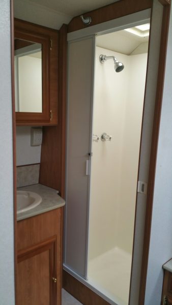 Shower and right of basin and cupboards